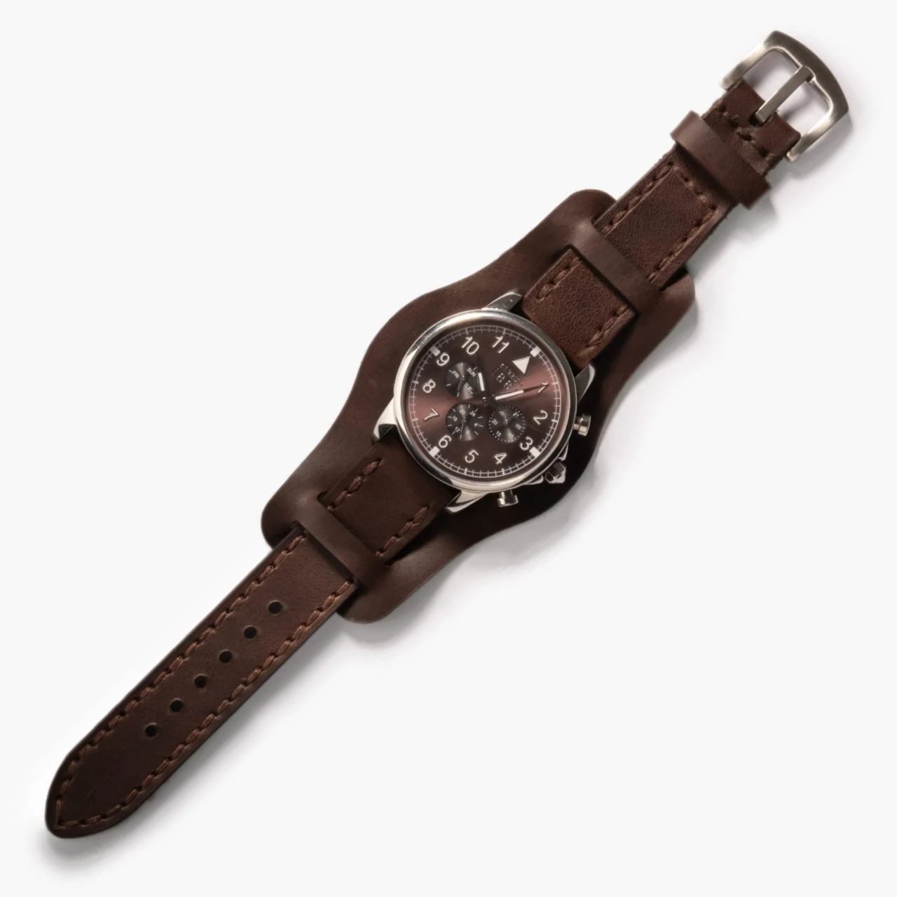 Bund Çift Katlı Deri Kayış – Acı Kahve, doğal ışık altında masa üstünde açık şekilde duruyor