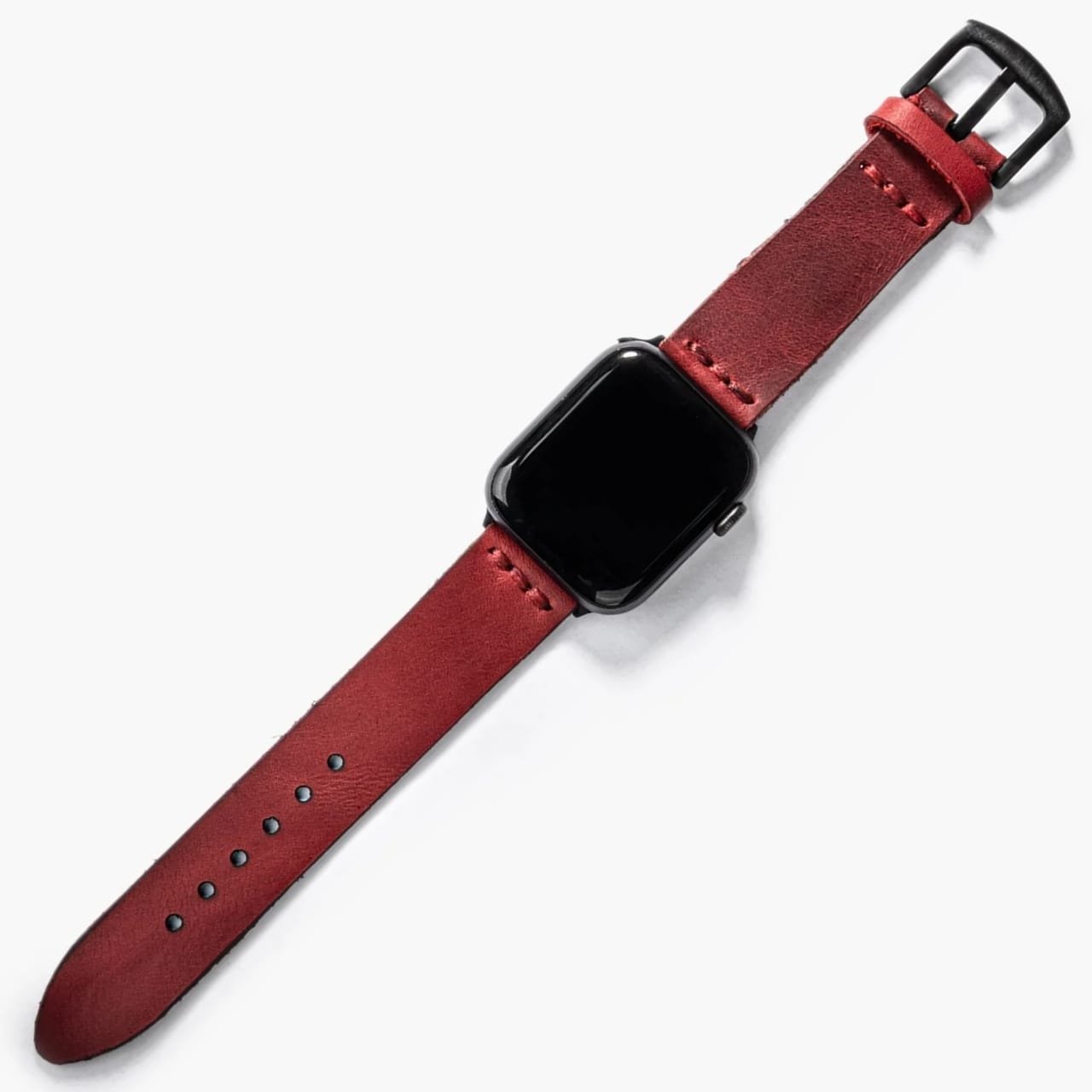 Tek Katlı Deri Apple Watch Kayışı – Kırmızı, masa üzerinde açık haliyle sergileniyor